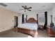 Comfortable bedroom with a large wooden bed frame, ceiling fan, and natural lighting at 10212 Cider Mill Rd, Las Vegas, NV 89135