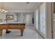 Well-lit game room with a pool table, elegant lighting, and access to the main entrance at 10212 Cider Mill Rd, Las Vegas, NV 89135
