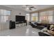 Bright living room with tile floors, large windows, ceiling fan, and a comfortable leather sofa at 10212 Cider Mill Rd, Las Vegas, NV 89135
