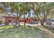Community playground shaded by mature trees and with covered picnic area, benches and play equipment at 10212 Cider Mill Rd, Las Vegas, NV 89135