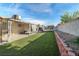Spacious backyard with artificial grass, covered patio, and block wall fencing at 1105 Declaration Dr, Las Vegas, NV 89110