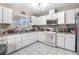 Bright kitchen with white cabinets, tile flooring, and a window over the sink at 1105 Declaration Dr, Las Vegas, NV 89110