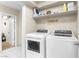 Functional laundry room with modern washer and dryer units, and storage shelving at 1105 Declaration Dr, Las Vegas, NV 89110