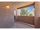 Private balcony offers a relaxing outdoor space with stucco walls and views of the surrounding trees and landscaping at 1150 N Buffalo Dr # 2025, Las Vegas, NV 89128