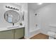 Modern bathroom with sleek fixtures, green cabinets, a round mirror and a shower-tub combination at 1150 N Buffalo Dr # 2025, Las Vegas, NV 89128