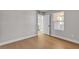 Well-lit bedroom with wood floors, neutral walls, and a door open to the hallway at 1150 N Buffalo Dr # 2025, Las Vegas, NV 89128