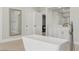 A bright bathroom features a freestanding tub, white cabinets, and a large mirror at 13 Dovetail Cir, Henderson, NV 89014