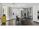 Bright dining area features hardwood floors, a glass table, modern chandelier, and black-framed room divider at 13 Dovetail Cir, Henderson, NV 89014