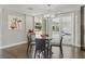 Open dining area with hardwood floors, a modern chandelier, and a view of the glass enclosed sunroom at 13 Dovetail Cir, Henderson, NV 89014
