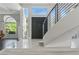 Open-concept foyer featuring staircase access to upper level, grand ceilings, and marble flooring at 13 Dovetail Cir, Henderson, NV 89014