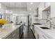 Well-lit kitchen features stainless appliances, an island with granite countertops, modern pendant lighting, and hardwood floors at 13 Dovetail Cir, Henderson, NV 89014