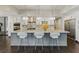 Bright kitchen featuring stainless steel appliances, granite countertops, pendant lighting, and bar stool seating at the island at 13 Dovetail Cir, Henderson, NV 89014