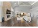 Open-concept living room featuring hardwood floors, fireplace, modern furniture, and an open kitchen at 13 Dovetail Cir, Henderson, NV 89014