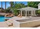 Luxurious pool with a rock waterfall, pergola, deck chair and desert landscaping at 13 Dovetail Cir, Henderson, NV 89014