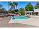Swimming pool with palm trees, rock waterfall, and shaded pergola with seating at 13 Dovetail Cir, Henderson, NV 89014