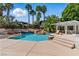 Backyard pool with rock waterfall feature and shaded pergola with lounge chair at 13 Dovetail Cir, Henderson, NV 89014
