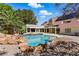 Stunning pool with rock features, surrounded by lush landscaping and a spacious patio, with a home in the background at 13 Dovetail Cir, Henderson, NV 89014
