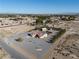Wide areal view of a property featuring a backyard pool, landscaping, a garage, and outbuildings at 1361 Moose St, Pahrump, NV 89048