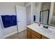 Bright bathroom with tile floors, oak vanity, shower and white painted door at 1361 Moose St, Pahrump, NV 89048
