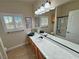 Bright bathroom featuring double windows, extended countertop, and glass enclosed shower at 1361 Moose St, Pahrump, NV 89048