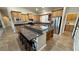 Open kitchen with island, stainless appliances, wooden cabinetry, granite counters, and bar stool seating at 1361 Moose St, Pahrump, NV 89048