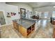 Kitchen island with stone countertop, wood cabinets, stainless dishwasher, with the dining area in the background at 1361 Moose St, Pahrump, NV 89048