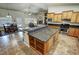Kitchen island with cooktop and cabinets with living room and fireplace in the background at 1361 Moose St, Pahrump, NV 89048