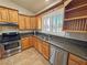 Kitchen view showcasing stainless steel appliances, wood cabinets, granite counters, and window at 1361 Moose St, Pahrump, NV 89048