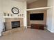 A cozy living room showcases a tiled fireplace with a clock and adjacent tv area at 1361 Moose St, Pahrump, NV 89048