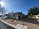 Backyard with mature trees and partial view of the home's exterior at 1429 S Sandhill Rd, Las Vegas, NV 89104