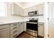 Well-lit kitchen with modern stainless steel appliances and sleek countertops with updated cabinets at 1601 Iguana St, Pahrump, NV 89048