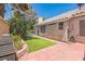 Private backyard with artificial grass, brick pavers, and desert landscaping at 169 Alterra Dr, Henderson, NV 89074