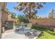 Landscaped backyard with an outdoor dining set, artificial grass, and desert landscaping at 169 Alterra Dr, Henderson, NV 89074