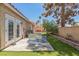 Private backyard offers a patio with artificial grass, a lush tree, and desert landscaping at 169 Alterra Dr, Henderson, NV 89074