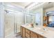 Well-lit bathroom with a double sink vanity, shower, and large mirror at 169 Alterra Dr, Henderson, NV 89074