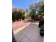 Landscaped backyard with concrete tiling is enhanced by flowering trees and surrounding greenery at 1748 Jupiter Ct # C, Las Vegas, NV 89119