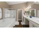 Bright bathroom featuring a glass shower, double sinks, and wood-look floors at 2025 Dakota Lodge Ave, Las Vegas, NV 89123