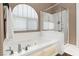 Bathroom showcasing a bathtub, glass shower, and arched window with blinds at 2025 Dakota Lodge Ave, Las Vegas, NV 89123