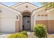 Inviting front entrance with three-car garage, desert landscaping, and stylish front door at 2025 Dakota Lodge Ave, Las Vegas, NV 89123