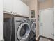 Well-equipped laundry room with front-loading washer and dryer, and storage cabinets above at 2025 Dakota Lodge Ave, Las Vegas, NV 89123