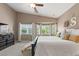 Bright main bedroom boasts a ceiling fan and sunlit windows with backyard views at 2025 Dakota Lodge Ave, Las Vegas, NV 89123