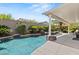 Tranquil backyard oasis with a freeform pool, lush landscaping, covered patio, and ample seating at 2025 Dakota Lodge Ave, Las Vegas, NV 89123