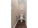 Neutral powder room with dark wood-look tile flooring and artwork on wall at 2025 Dakota Lodge Ave, Las Vegas, NV 89123