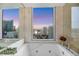 Spa-like bathroom featuring a soaking tub with city views and tiled walls at 222 Karen Ave # 3307, Las Vegas, NV 89109