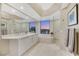 Luxurious bathroom with double sinks, a soaking tub, and a glass-enclosed shower with city views at 222 Karen Ave # 3307, Las Vegas, NV 89109
