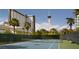 Tennis court surrounded by lush greenery with the Stratosphere peeking above the tree line at 222 Karen Ave # 3307, Las Vegas, NV 89109