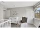 Bedroom with neutral tones, a crib, recliner, changing table and a window view at 2418 Antler Point Dr, Henderson, NV 89074