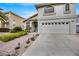 Beautiful two-story home showcases a manicured lawn, a brick walkway, and an attached two car garage at 2418 Antler Point Dr, Henderson, NV 89074