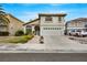 Elegant two-story home featuring a well-kept lawn, a brick pathway, and an attached two-car garage at 2418 Antler Point Dr, Henderson, NV 89074