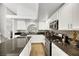Well-lit kitchen boasts white cabinets, black granite countertops, and stainless steel appliances at 2418 Antler Point Dr, Henderson, NV 89074